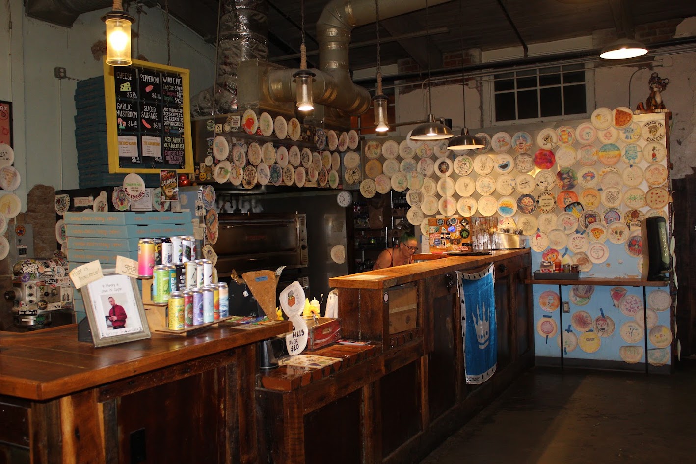 Benny Pennello's pizza counter with menu boards, drinks, and decorated paper plates