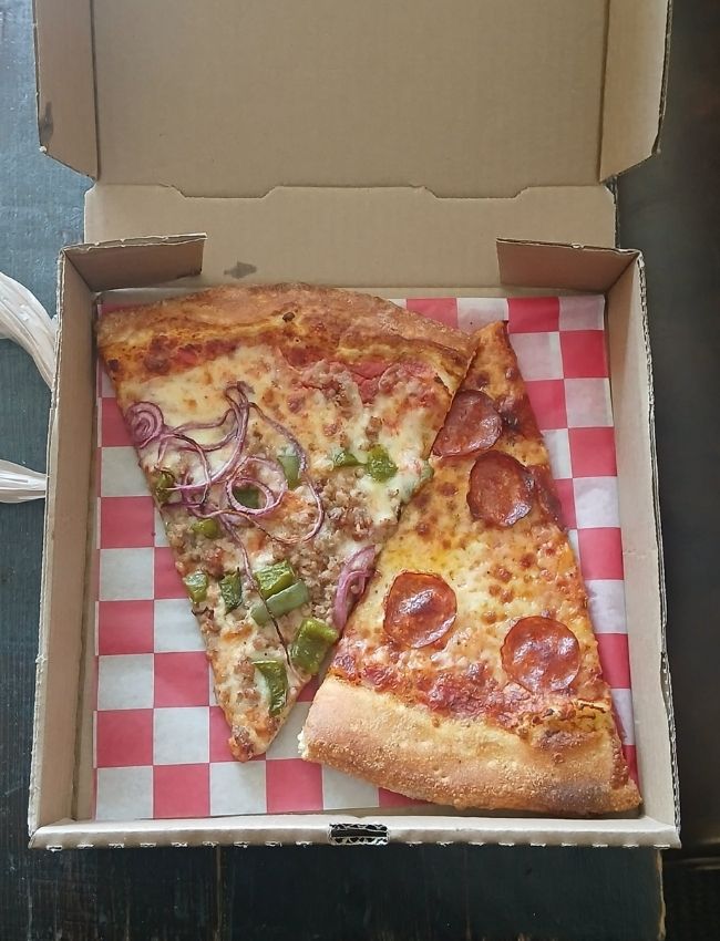 Overhead view of two pizza slices from Carmella’s Pizza Grill in Charlotte