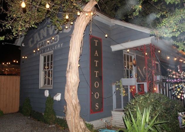 Canvas Tattoo and Art Gallery exterior with illuminated lights in NoDa Charlotte