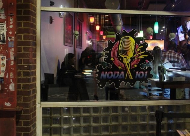 NoDa 101 karaoke bar window with guests and colorful lighting in Charlotte